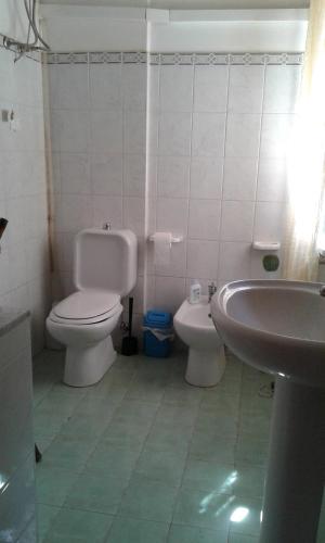 a bathroom with a toilet and a sink at Estrellas De Mar Casa in Giardini Naxos