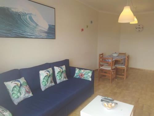 a living room with a blue couch and a table at Foz do Guadiana in Vila Real de Santo António