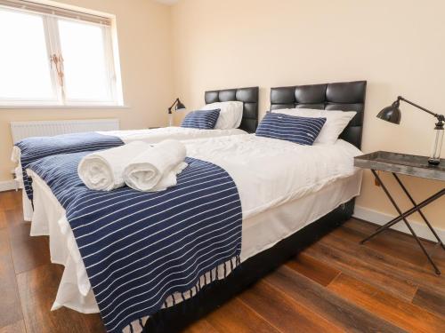 ein Schlafzimmer mit einem großen Bett mit zwei Handtüchern darauf in der Unterkunft The Beach House in Cleveleys