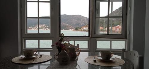 a room with two tables with cups on them and windows at Apartamento Chamela in O Pindo