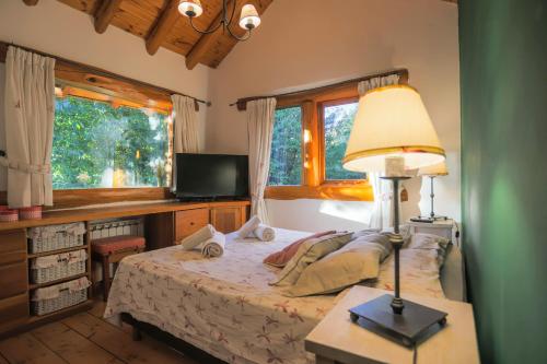 a bedroom with a bed and a desk with a lamp at Al pie del Campanario in San Carlos de Bariloche