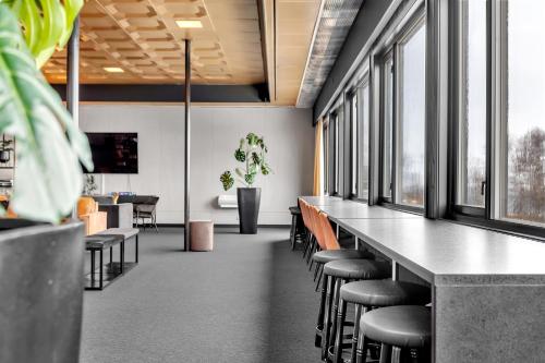 a row of tables and chairs in a room with windows at Robukta Lodge in Tromsø