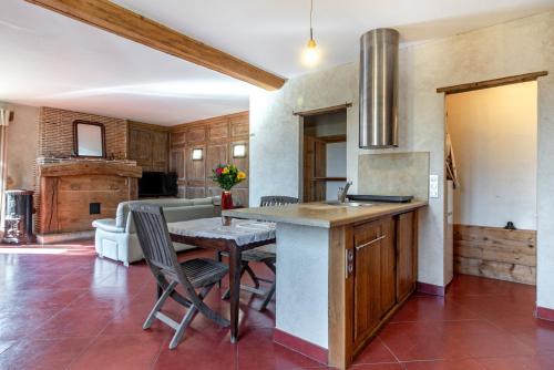 une cuisine et une salle à manger avec une table et des chaises dans l'établissement Petite Maison de Jeanne - Corps de ferme rénové, à Épervans