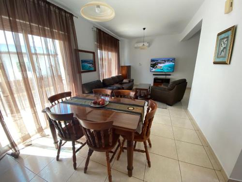 uma sala de estar com uma mesa e cadeiras e um sofá em Three Bedroom Casa de Paphos em Pafos