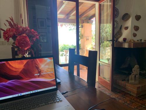 a laptop computer sitting on a wooden table with a fireplace at Villa Matteo sea view in Torre delle Stelle