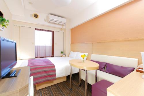 a hotel room with a bed and a table at HOTEL MYSTAYS Asakusa in Tokyo