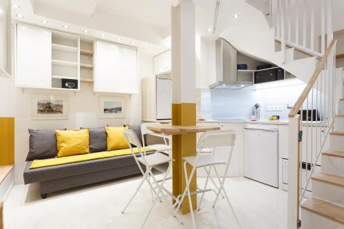 a living room with a couch and a table and chairs at Appartement Petits Champs in Paris