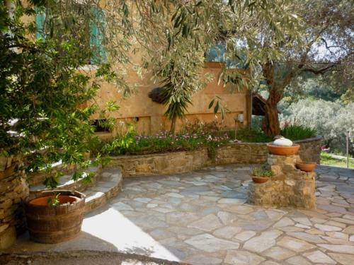 a garden with a stone patio with potted plants at Studio south Pilion in Chorto