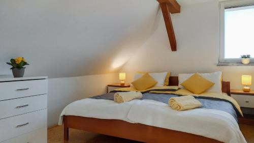 a bedroom with a large bed with yellow pillows at Apartments Vinska Trta in Čatež ob Savi