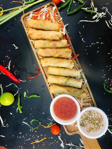 a tray of food on a table with dipping sauce at Al Ain Palace Hotel Abu Dhabi in Abu Dhabi