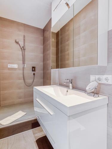 a bathroom with a white sink and a shower at Limehome Aalen Reichsstädter Str in Aalen