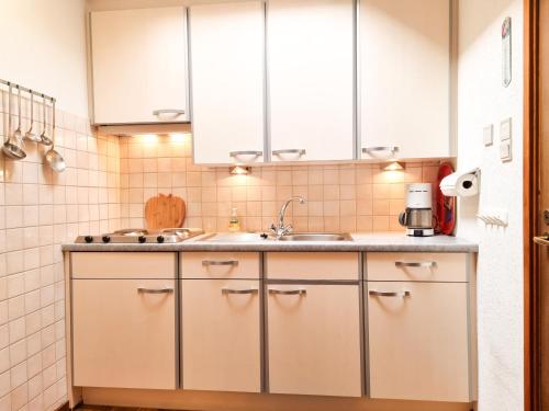 a kitchen with white cabinets and a sink at Gezellige vakantiewoning dichtbij centrum Domburg DO20 in Domburg