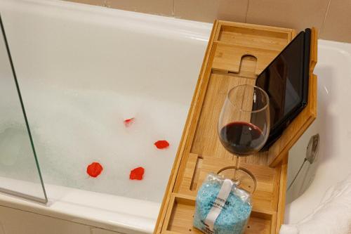 a glass of wine in a bath tub with a glass of red wine at Pensión Úbeda in Fuenmayor