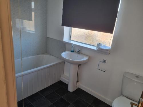 a bathroom with a sink and a toilet and a bath tub at Collins Avenue in Norton