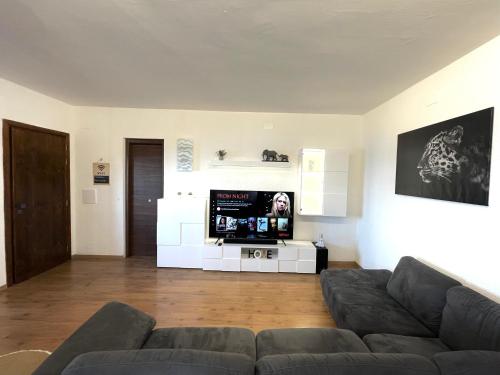 a living room with a couch and a flat screen tv at MiCasaEsTuCasa in Porto Santo Stefano