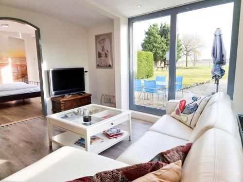 a living room with a white couch and a tv at Vakantiewoning Goedgelegen MB01 in Middelburg