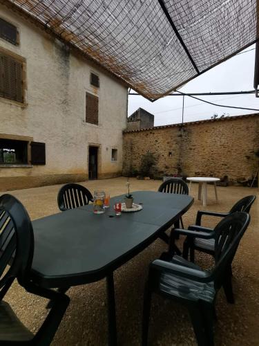 une table et des chaises devant un bâtiment dans l'établissement L Oustal du Malbernat, à Frayssinet-le-Gélat
