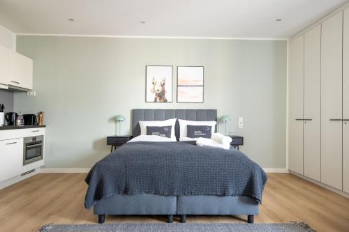 a bedroom with a bed with a blue blanket at Limehome Aalen Reichsstädter Str in Aalen