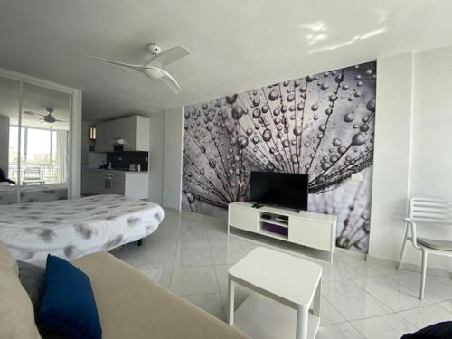 een kamer met een bed, een tv en een bank bij EL DORADO HOLIDAYS in Playa de las Americas