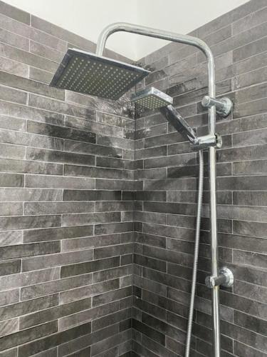 een douche met een licht op een bakstenen muur bij EL DORADO HOLIDAYS in Playa de las Americas