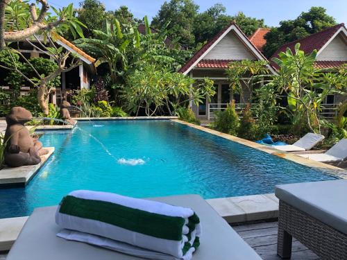 a pool with a towel on a table next to a house at Le Biu garden View in Nusa Lembongan
