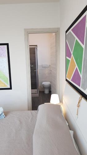 a bedroom with a bed and a bathroom with a toilet at B&B Villa Giulia in Desenzano del Garda