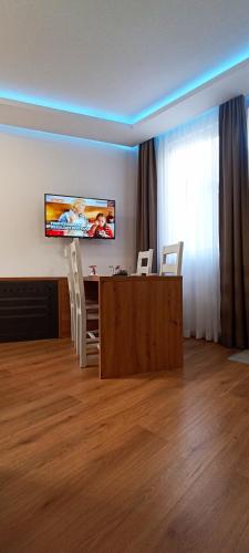 a living room with a television and a table and chairs at Apartments "Tuffo" in Sarajevo