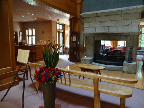 a lobby with a fireplace and a vase of flowers at Chuzenji Kanaya Hotel in Nikko