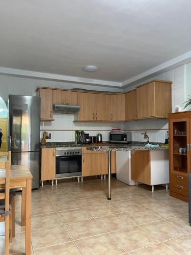 una cucina con armadietti in legno ed elettrodomestici in acciaio inossidabile di Apartment Playa las Vistas a Playa de las Americas