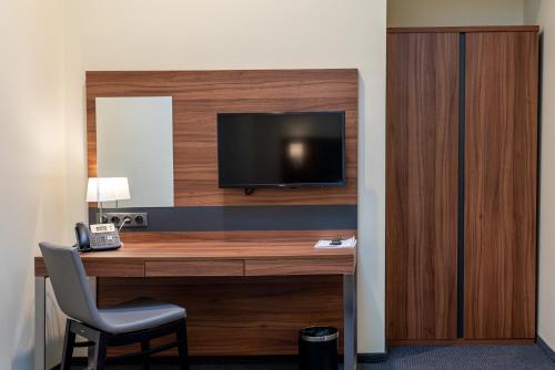 a room with a desk with a television and a chair at Hotel Wodnik in Bydgoszcz