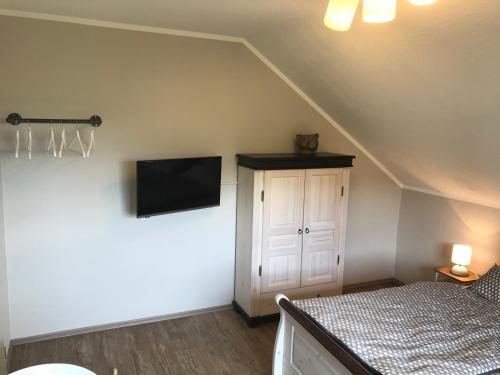 a bedroom with a bed and a tv on the wall at Landhaus Sonneninsel - Appartement in Minheim