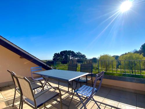 d'une table et de chaises sur un balcon bien exposé. dans l'établissement REF 004 Studio Terrasses de Kerjouanno plage du Fogeo à pieds, à Arzon