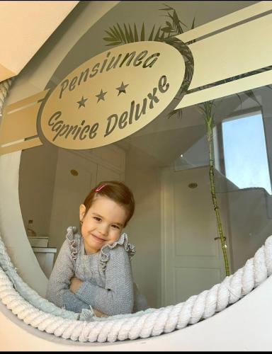 a little girl sitting in front of a mirror at Caprice Deluxe Accomodation in Drobeta-Turnu Severin