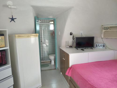 a room with a bathroom with a toilet and a television at Cabanas de Tucuns in Búzios
