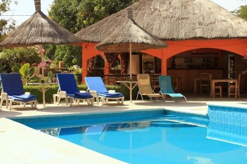a resort with chairs and a swimming pool at B & B Mariamacounda in Toubakouta