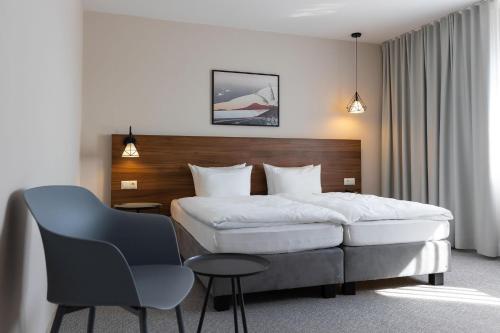 a hotel room with a bed and a chair at Hotel Santin in Bełchatów