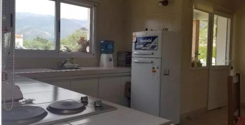 a kitchen with a white refrigerator and a window at Cabañas Cafayate in Cafayate