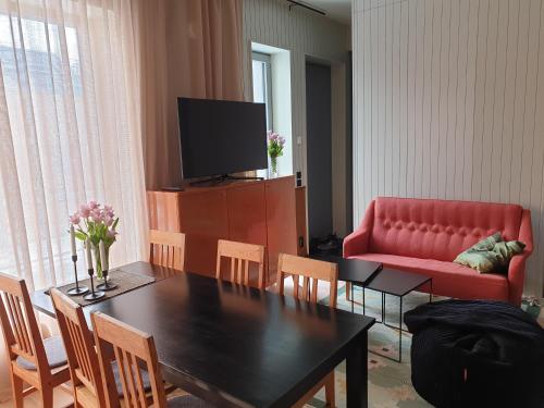 a living room with a table and a red couch at Viste Funäsdalen in Funäsdalen