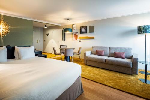 ディーゲムにあるホリデイ イン ホテル ブリュッセル エアポートのベッドとソファ付きのホテルルーム