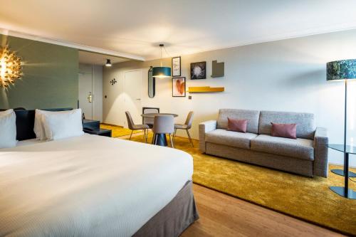 a hotel room with a bed and a couch at Holiday Inn Hotel Brussels Airport, an IHG Hotel in Diegem