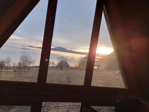 a view from a window of a field with the sunset at Razele Trascaului in Rîmeţi