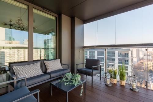 a living room with a couch and chairs and windows at Mennica Residence Luxury Suite by Renters Prestige in Warsaw