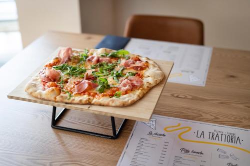 a pizza sitting on a cutting board on a table at JUFA Hotel Wipptal in Steinach am Brenner