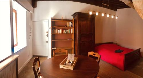 Zimmer mit einem Tisch und einem Bett sowie einem Tisch und Stühlen in der Unterkunft Joli studio de caractère in Gray