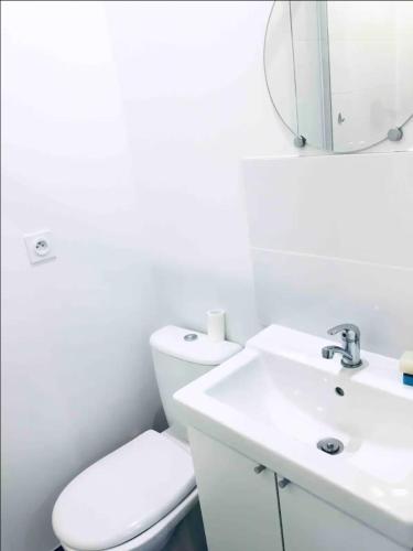 a white bathroom with a toilet and a sink at Joli Studio in Gray