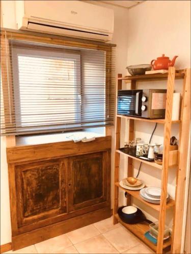 a kitchen with a window and a shelf with a microwave at Joli Studio in Gray