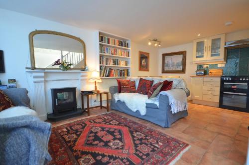 a living room with a couch and a fireplace at Arch Cottage in Chagford