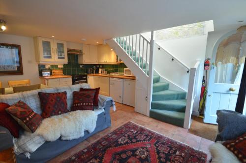 a living room with a couch and a staircase at Arch Cottage in Chagford