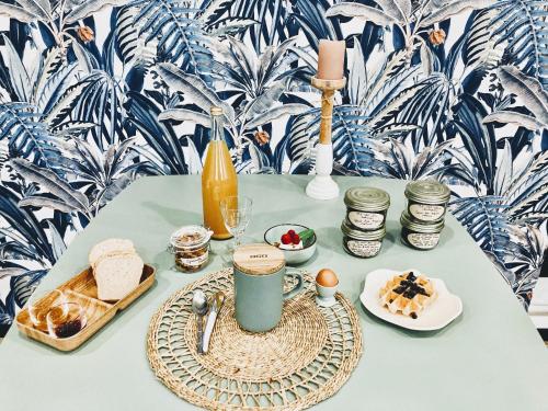 a table with a plate of food and a drink at La Tuilerie Chambres d'Hôtes in Saint Die