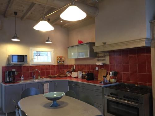 une cuisine avec une table, un évier et une cuisinière dans l'établissement Maison au bord de mer, à Saintes-Maries-de-la-Mer